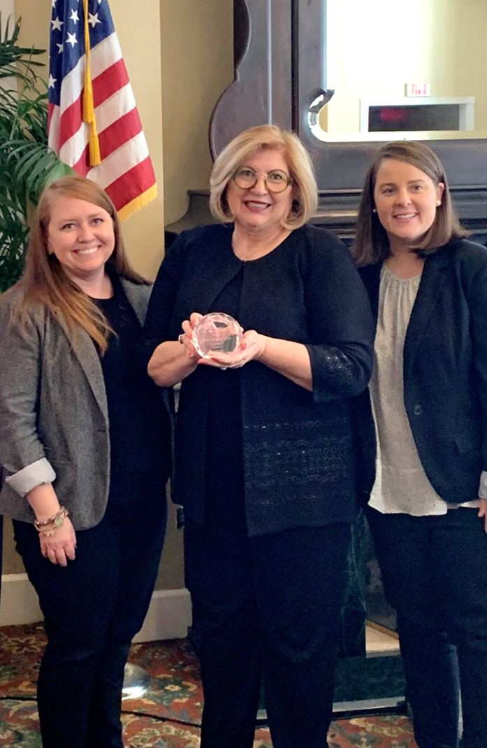 Public Affairs Committee Co-Chairs Maggie McCleland and Melanie accept the 'Outstanding Public Policy & Advocacy Award', presented by Senator Janet Cruz. 